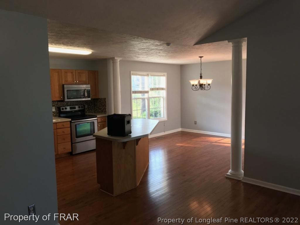 154 Chesapeake Road Cameron, NC 28326 - Photo 9 of 29 a view of a kitchen with kitchen island wooden floors appliances