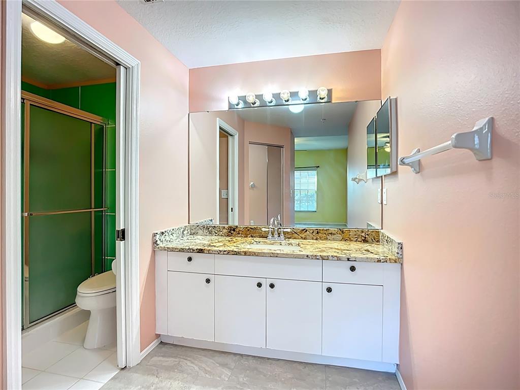6330 Green Oak Circle, Unit 6330 Bradenton, FL 34203 - Photo 17 of 58 a spacious bathroom with a granite countertop toilet sink and mirror