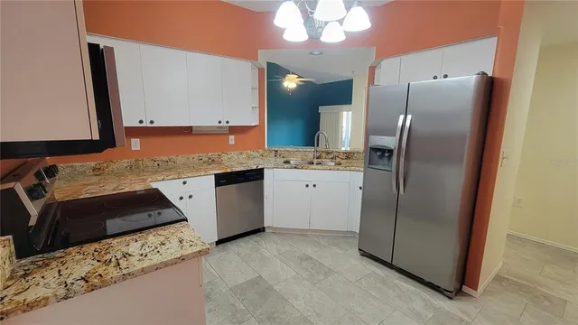 a kitchen with stainless steel appliances granite countertop a refrigerator and a sink
