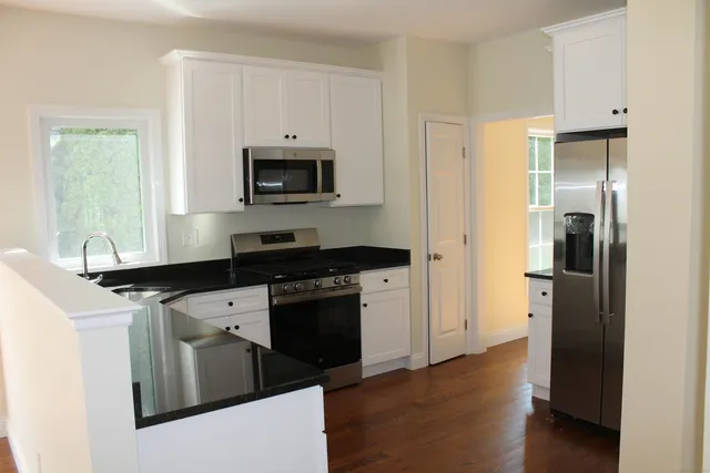a kitchen with stainless steel appliances granite countertop a refrigerator and a stove