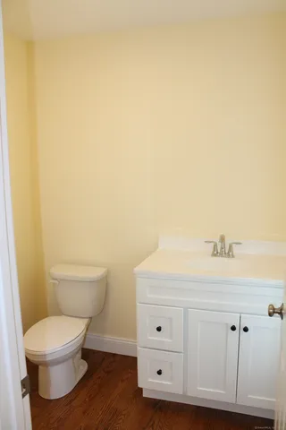 a bathroom with a toilet a sink a vanity and mirror