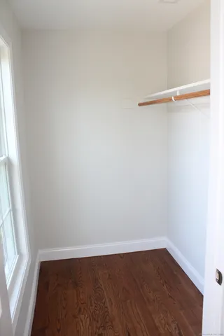 a view of a small space with wooden floor and a window