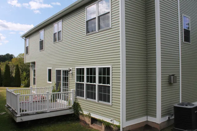 a view of a house with a small deck and a floor to ceiling window