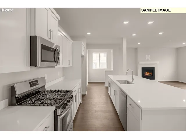 a large kitchen with stainless steel appliances granite countertop a stove a sink and a microwave