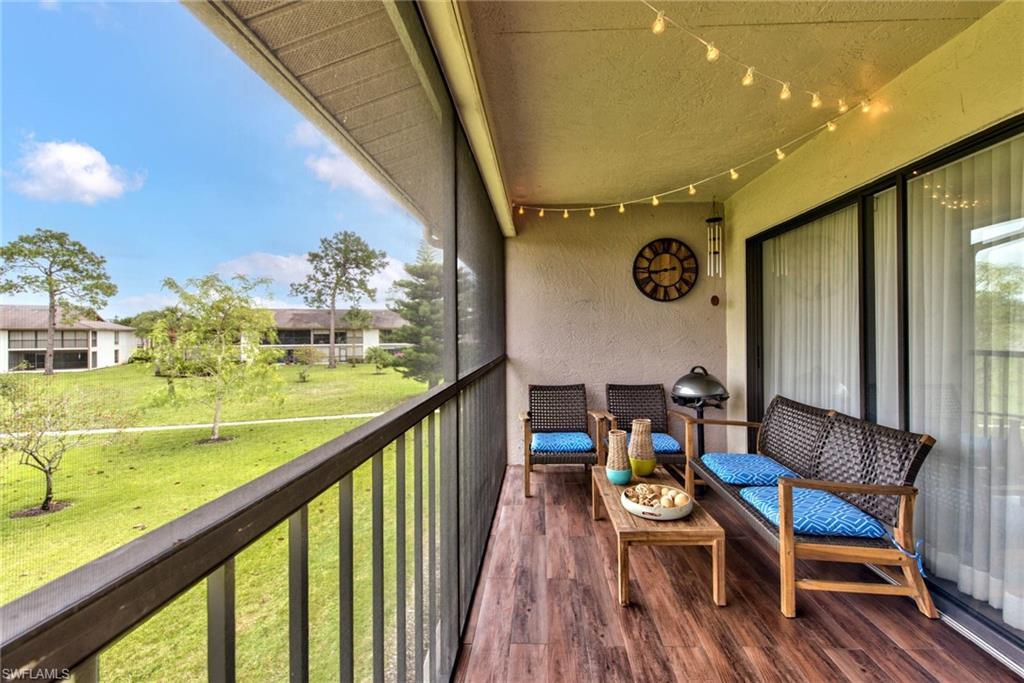 1224 Commonwealth Circle, Unit N204 Naples, FL 34116 - Photo 19 of 33 a view of balcony with furniture and wooden floor