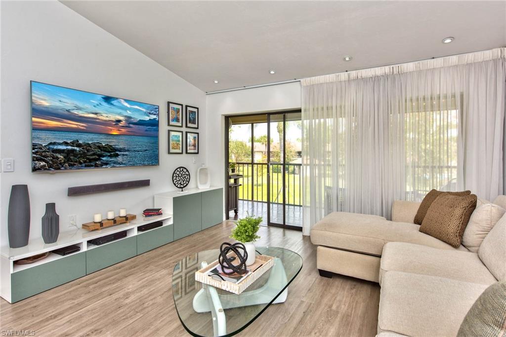 1224 Commonwealth Circle, Unit N204 Naples, FL 34116 - Photo 21 of 33 a living room with furniture and a flat screen tv