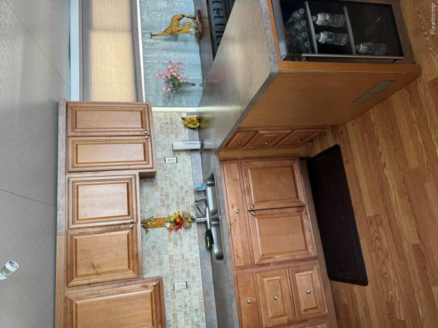 10001 Goodall Road, Unit 404 Durand, MI 48429 - Photo 16 of 50 Kitchen featuring a peninsula, dark countertops, light wood-style flooring, and wood finish cabinets