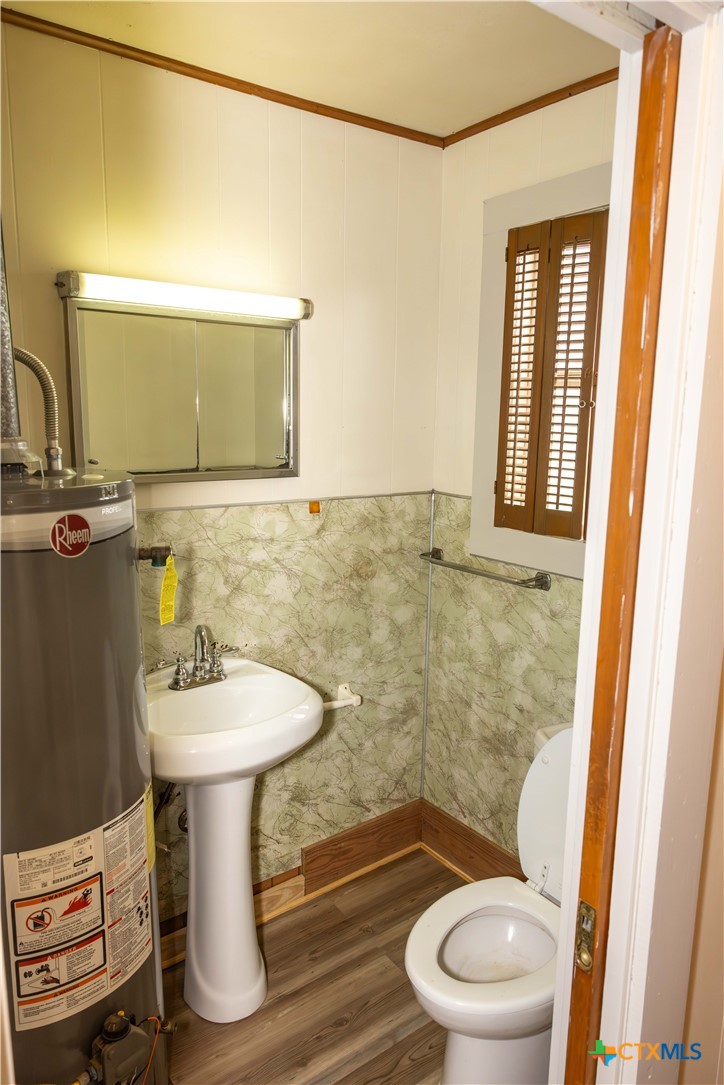204 Orth Street Yoakum, TX 77995 - Photo 9 of 16 a bathroom with a sink a toilet a mirror and vanity
