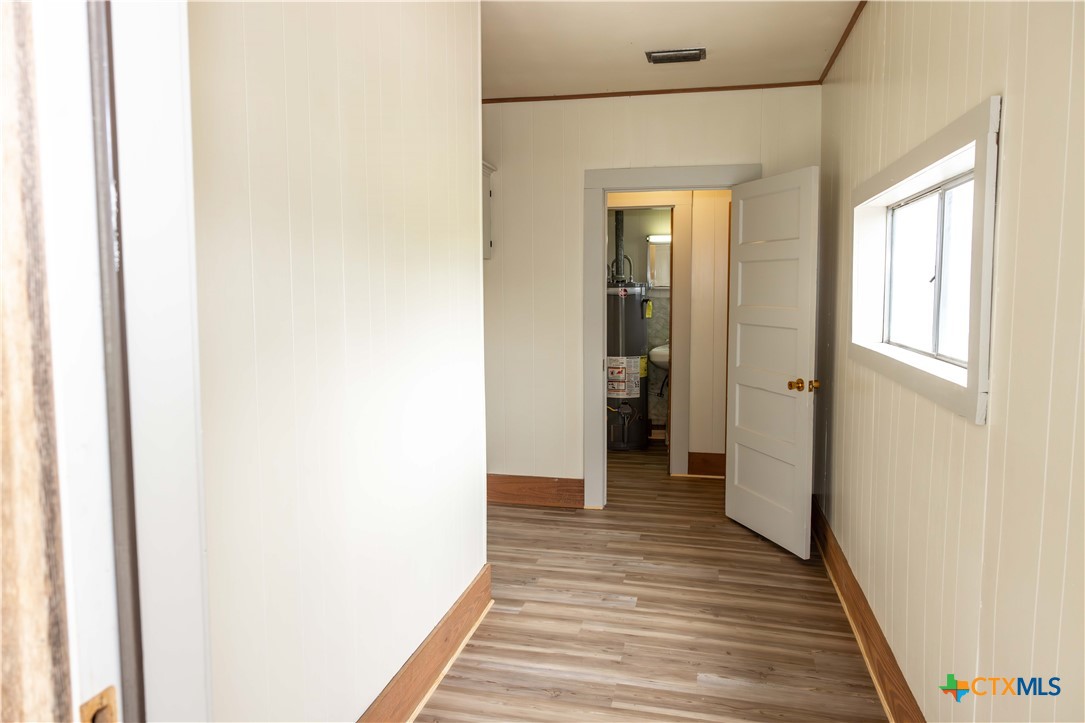 204 Orth Street Yoakum, TX 77995 - Photo 10 of 16 a view of a hallway with wooden floor and a bathroom