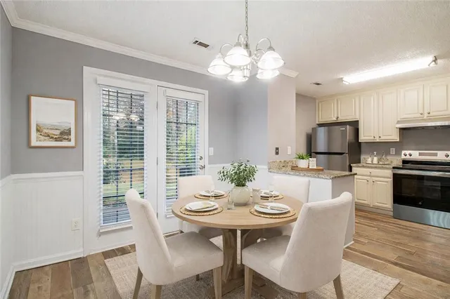 a view of a dining room with furniture a chandelier and wooden floor