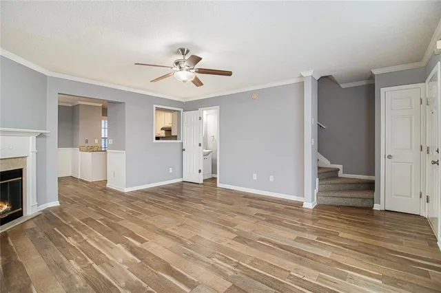 a view of empty room with wooden floor and fireplace
