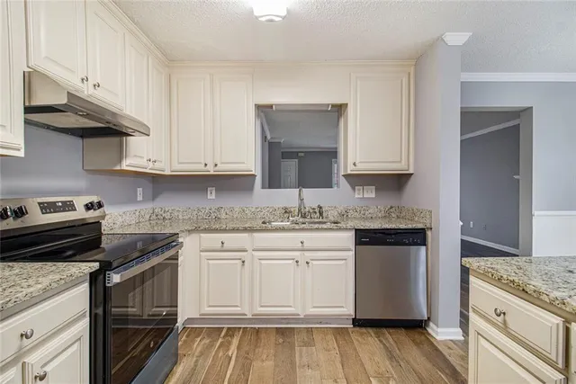a kitchen with granite countertop cabinets stainless steel appliances and a sink