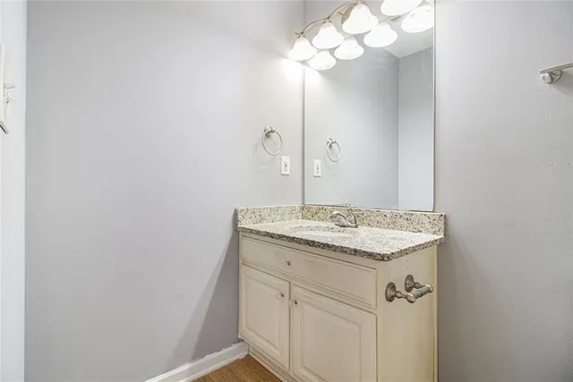 a bathroom with a granite countertop sink and a mirror