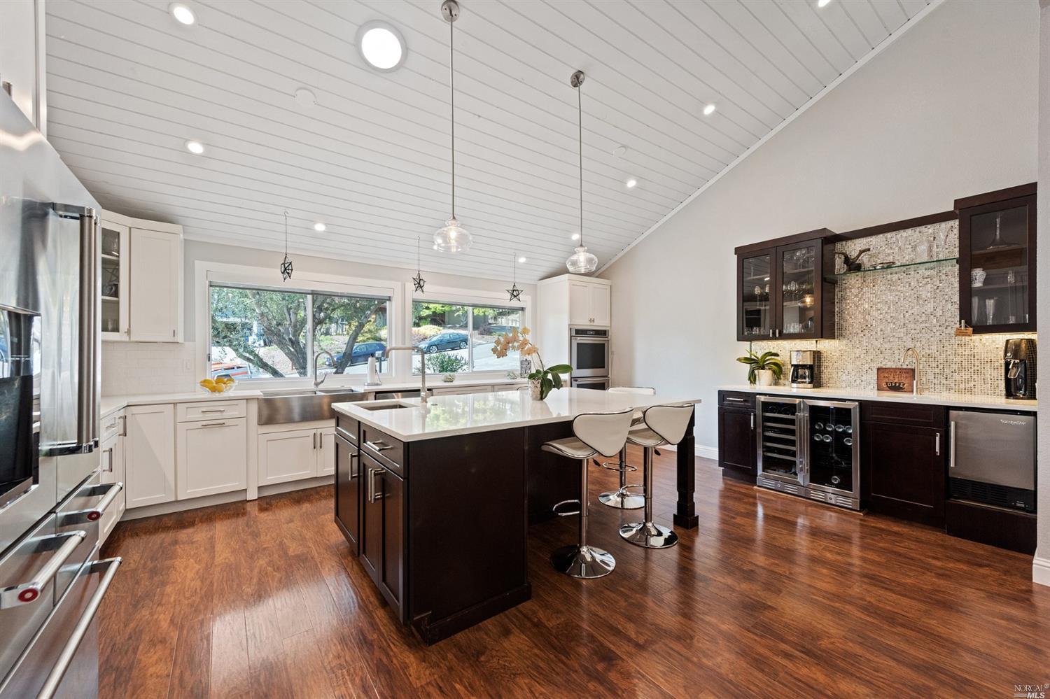 a kitchen with stainless steel appliances granite countertop wooden cabinets and wooden floors