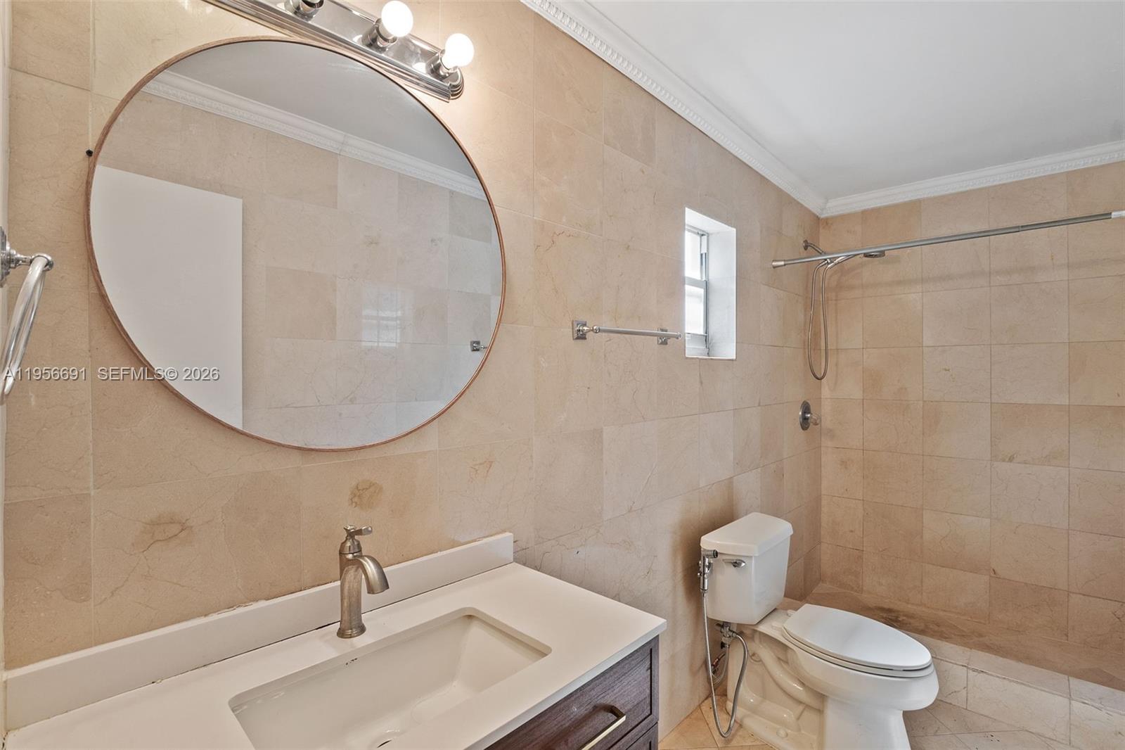 3880 East 8th Lane Hialeah, FL 33013 - Photo 19 of 26 a bathroom with a sink toilet and a mirror