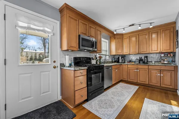 a kitchen with stainless steel appliances granite countertop a stove a sink and a microwave