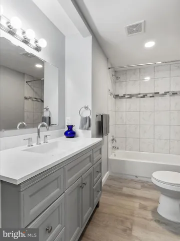 a bathroom with a double vanity sink toilet mirror and shower