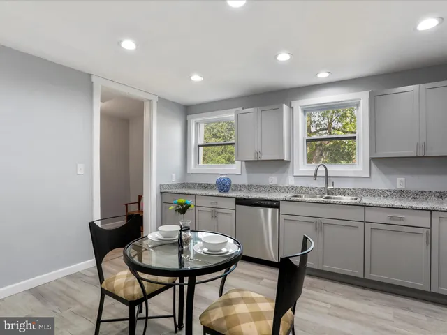 a kitchen with a dining table chairs and sink