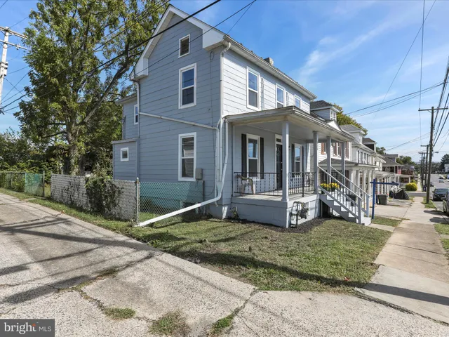 a view of a white house with large windows and a yard