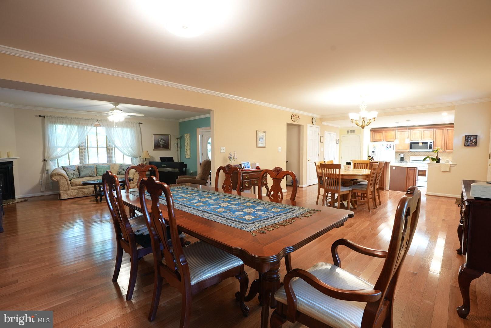 114 Salina Road Sewell, NJ 08080 - Photo 15 of 86 a view of a dining room and livingroom with furniture wooden floor a rug and a chandelier