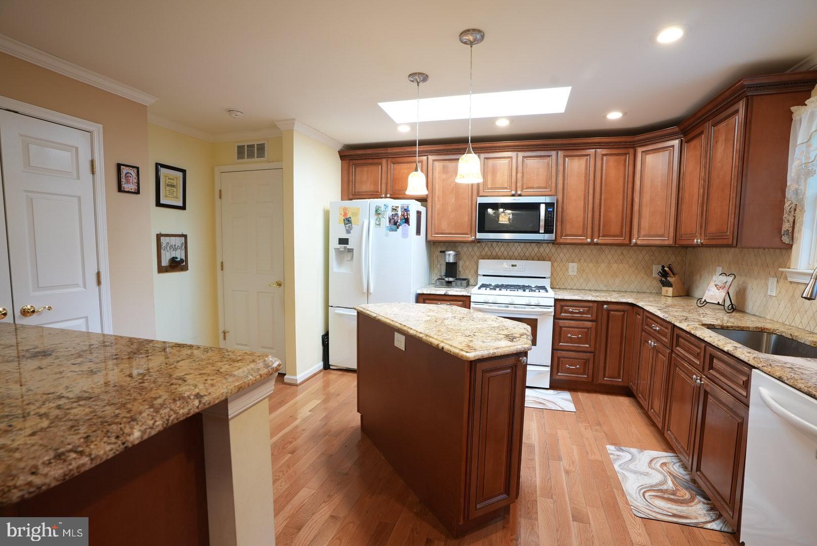 114 Salina Road Sewell, NJ 08080 - Photo 19 of 86 a kitchen with granite countertop a stove top oven a sink dishwasher and a refrigerator with wooden floor