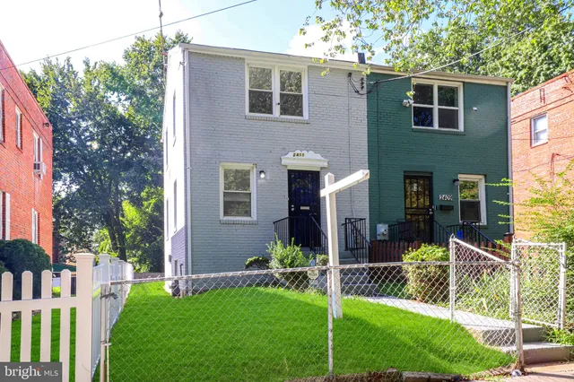 a view of a house with backyard and a tree