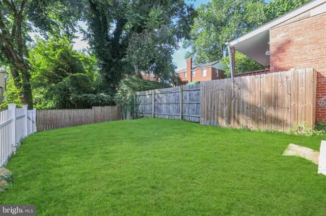 a view of a backyard with a small cabin and wooden fence