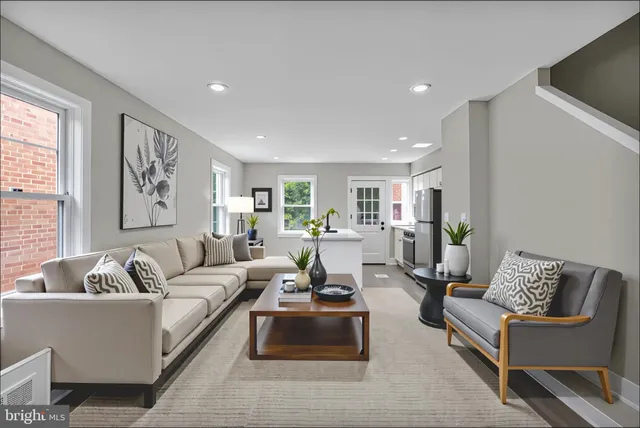a living room with furniture and view of kitchen