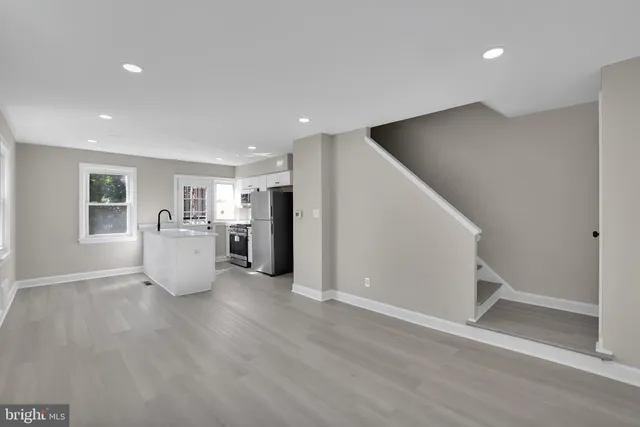 a view of a big room with wooden floor and windows