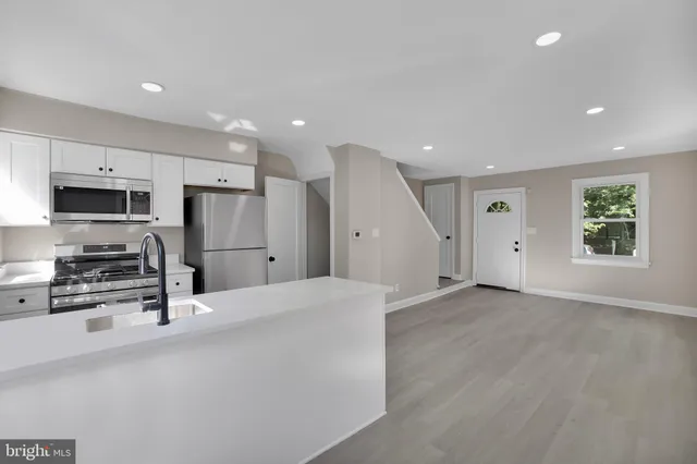 a kitchen with stainless steel appliances a refrigerator sink and microwave