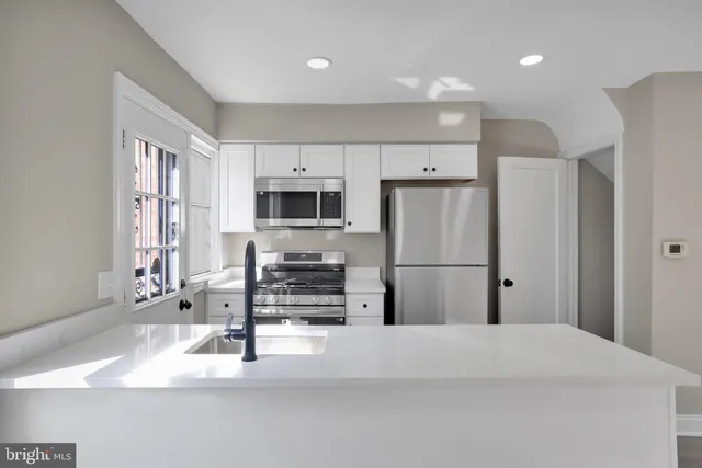 a kitchen with stainless steel appliances a refrigerator sink and microwave
