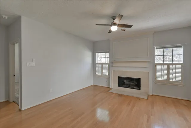 a view of an empty room with window and fire place