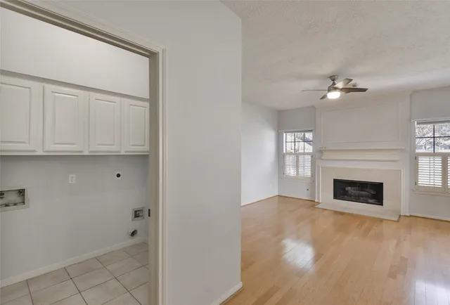 a view of an empty room with a fireplace and a window