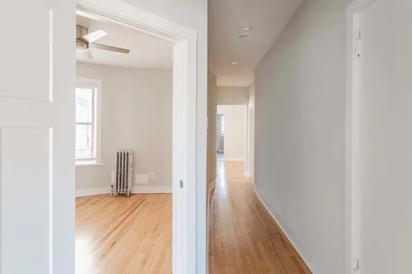 a view of a room with wooden floor and a window