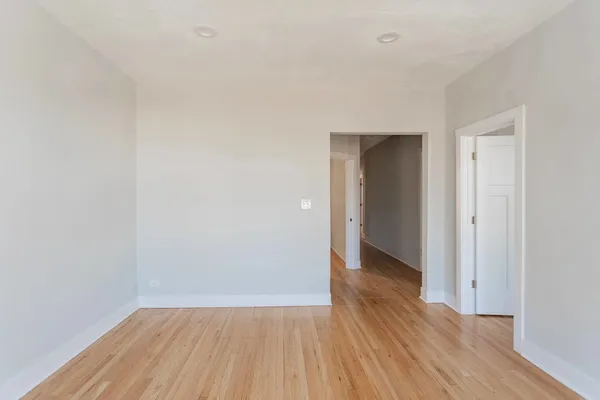 a view of an empty room with wooden floor