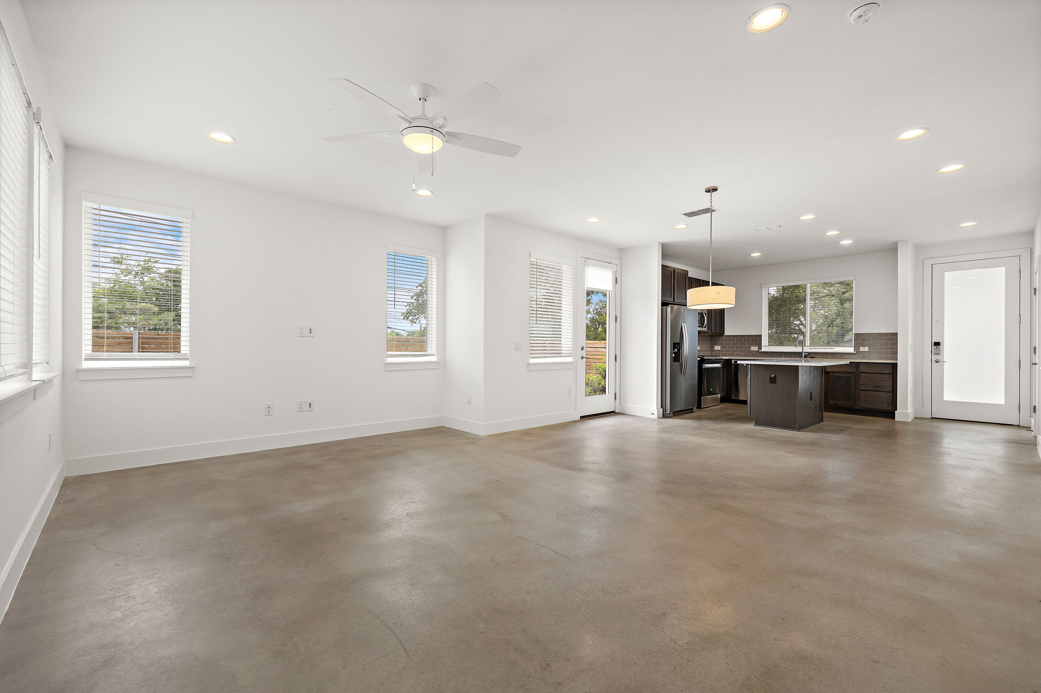 1206 Sarabeth Way Austin, TX 78721 - Photo 6 of 27 Unfurnished living room featuring baseboards, finished concrete floors, and recessed lighting