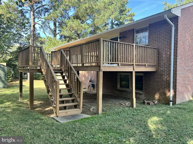a view of a house with backyard and deck
