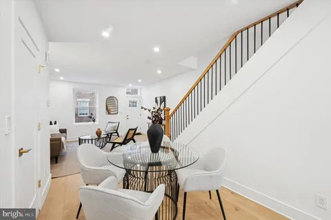 a dining room with furniture entryway and wooden floor