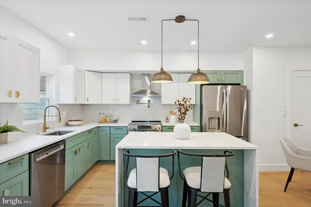 a kitchen with a dining table chairs and white cabinets
