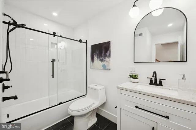 a bathroom with a granite countertop toilet sink and shower