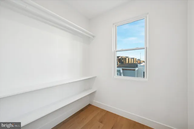 a view of small space with wooden floor and a window