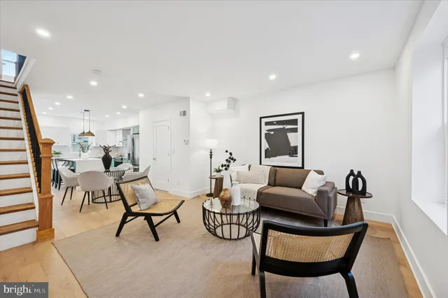 a living room with furniture and a view of kitchen