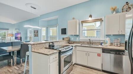 4765 Calatrava Court Destin, FL 32541 - Photo 11 of 34 a kitchen with stainless steel appliances granite countertop a sink stove and cabinets