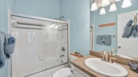 a bathroom with a granite countertop sink toilet and shower