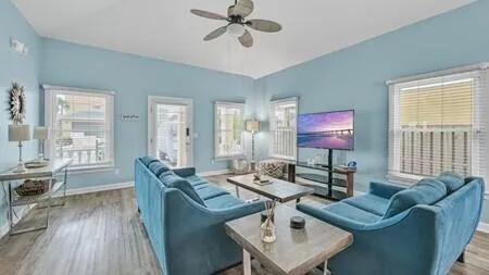 a living room with furniture a wooden floor and a window