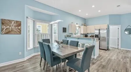 a kitchen with a table chairs refrigerator and microwave