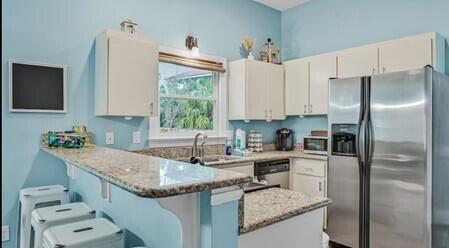 4765 Calatrava Court Destin, FL 32541 - Photo 9 of 34 a kitchen with stainless steel appliances granite countertop a sink stove and refrigerator