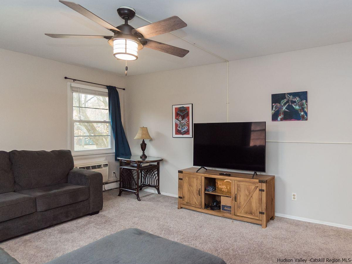 2710 South Road, Unit E4 Poughkeepsie, NY 12601 - Photo 3 of 13 a living room with furniture and a flat screen tv