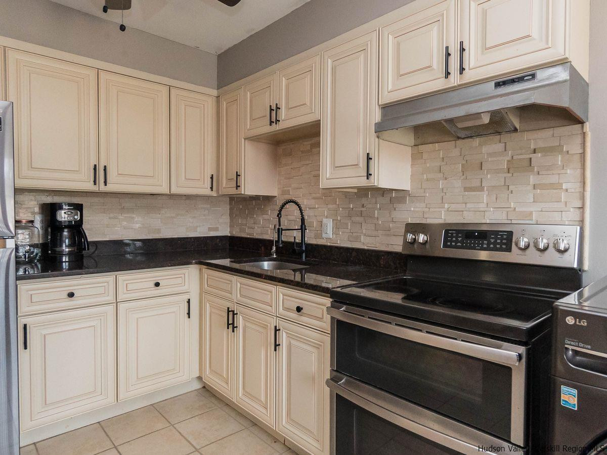 2710 South Road, Unit E4 Poughkeepsie, NY 12601 - Photo 5 of 13 a kitchen with white cabinets and appliances