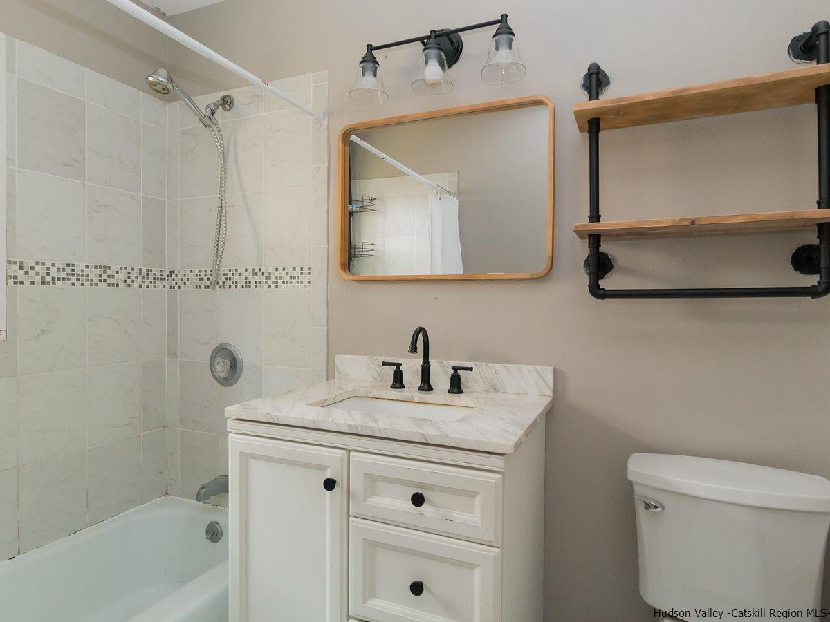 2710 South Road, Unit E4 Poughkeepsie, NY 12601 - Photo 10 of 13 a bathroom with a sink a mirror a toilet and a bathtub